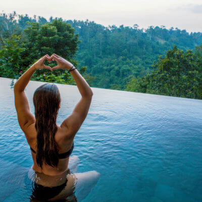 luxury yoga retreats - woman practicing yoga in an infinity pool