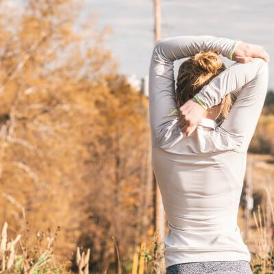 Woman stretching outside - best organic yoga clothes for travel or the studio