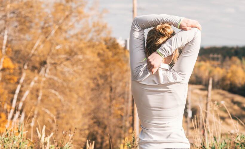 Woman stretching outside - best organic yoga clothes for travel or the studio