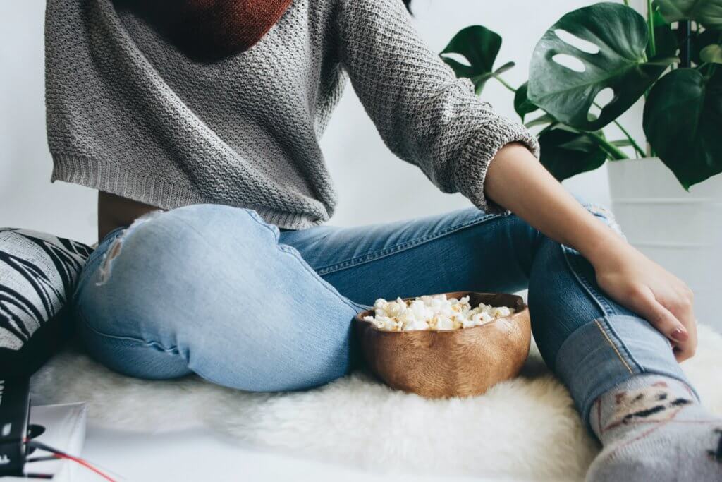 woman with bowl of popcorn - best yoga movies