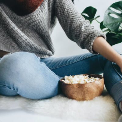 woman with bowl of popcorn - best yoga movies