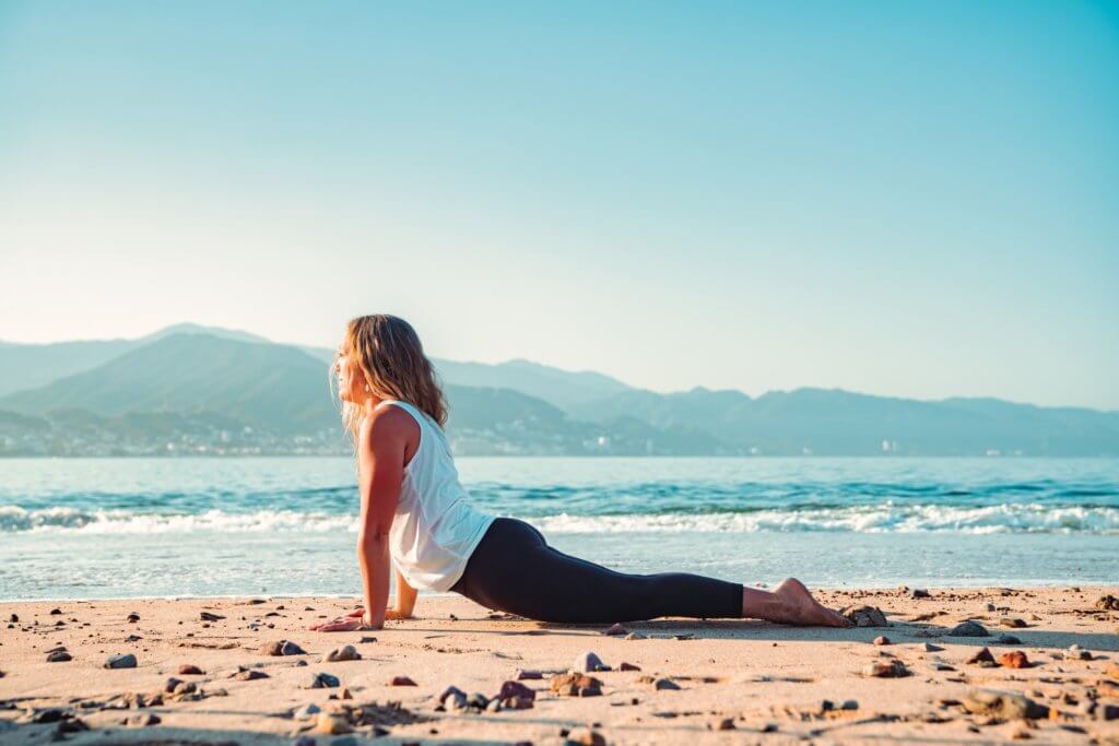woman doing yoga on the beach - Mexico yoga retreats 