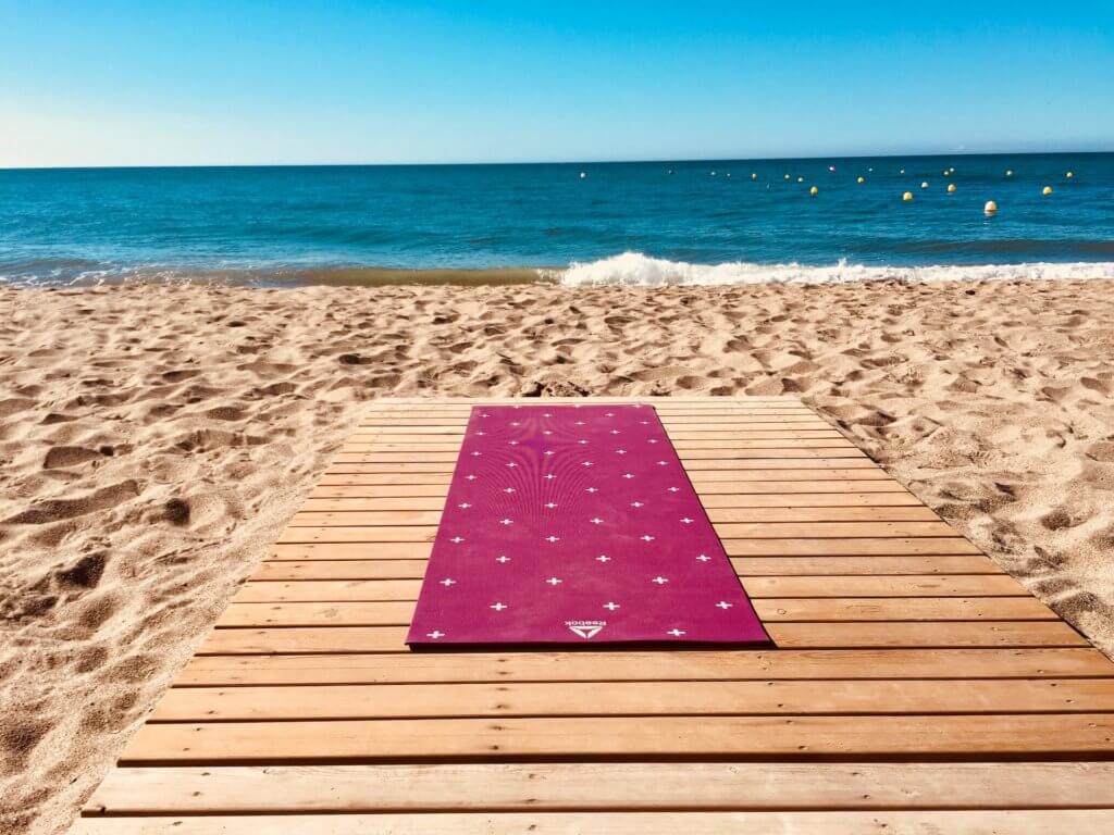 yoga mat on the beach - best yoga retreats in Spain
